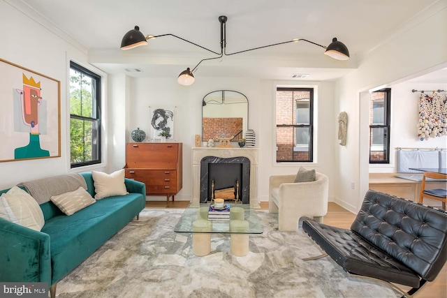 living area with wood finished floors, a premium fireplace, and crown molding