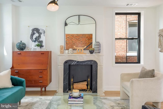sitting room featuring wood finished floors and a high end fireplace