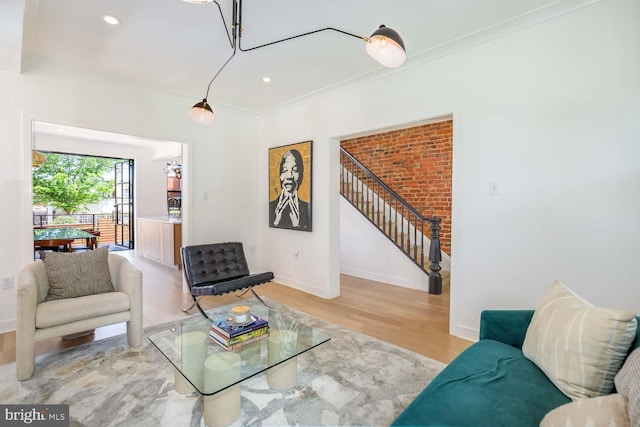 living area with stairway, light wood-style floors, baseboards, crown molding, and recessed lighting