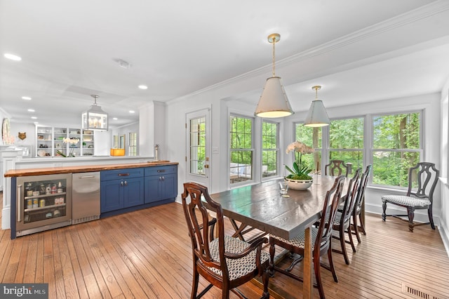 512 Worthington Rd, Chester Springs, PA 19425 - dining space with beverage cooler, light wood-style flooring, crown molding, recessed lighting, and a chandelier