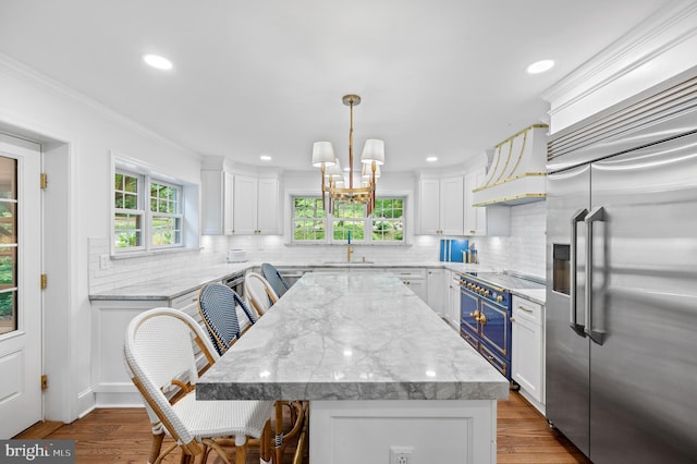 512 Worthington Rd, Chester Springs, PA 19425 - kitchen with premium appliances, white cabinetry, a kitchen island, crown molding, and custom exhaust hood