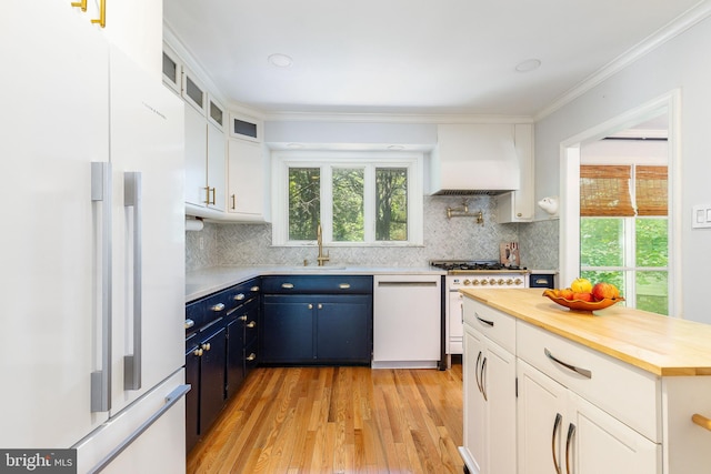 1128 Coventry Rd, Cheltenham, PA 19012 - kitchen with white appliances, premium range hood, light wood-type flooring, blue cabinetry, and a sink