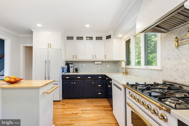 1128 Coventry Rd, Cheltenham, PA 19012 - kitchen with gas range, ventilation hood, a sink, white cabinetry, and white fridge