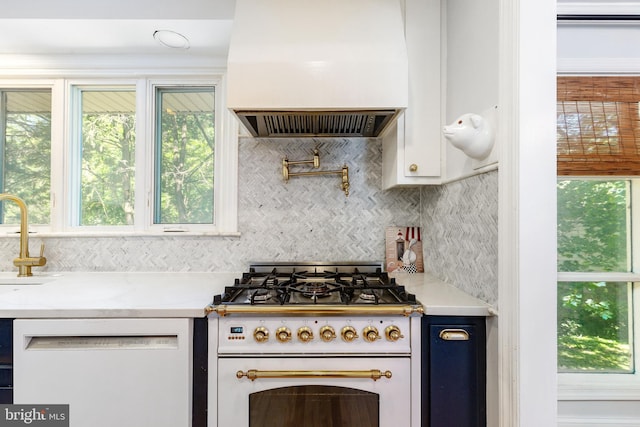 1128 Coventry Rd, Cheltenham, PA 19012 - kitchen with custom range hood, white appliances, tasteful backsplash, light countertops, and healthy amount of natural light