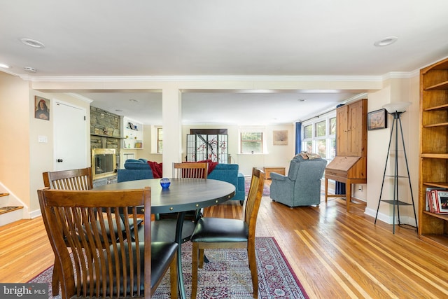 1128 Coventry Rd, Cheltenham, PA 19012 - dining room featuring crown molding, light wood-style flooring, a fireplace, and baseboards