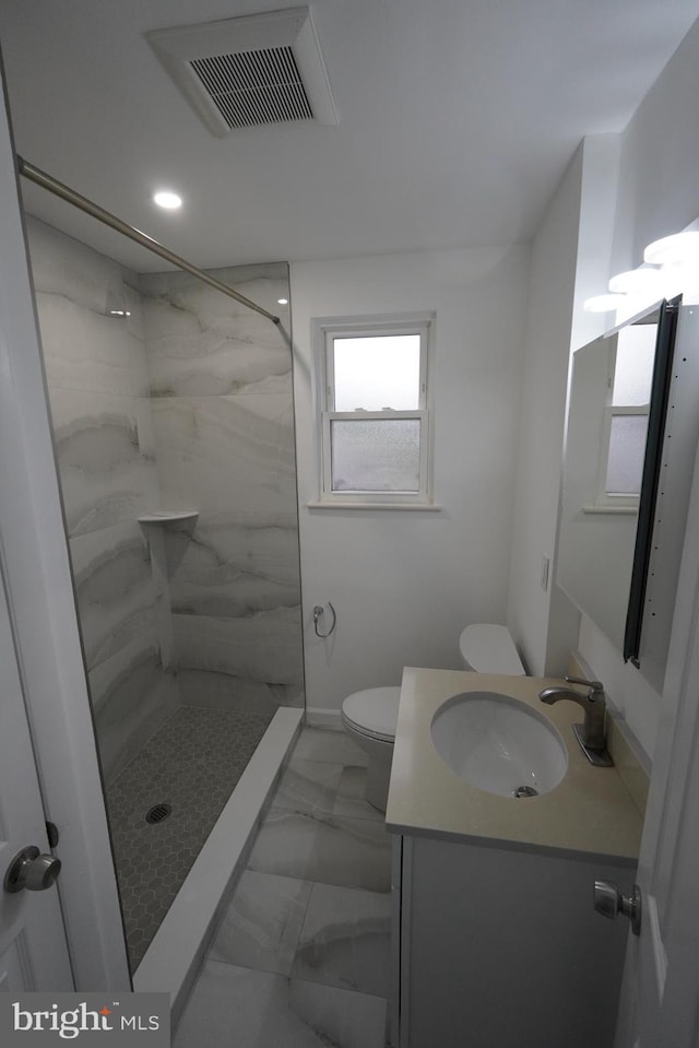 full bath featuring toilet, vanity, a walk in shower, and marble finish flooring