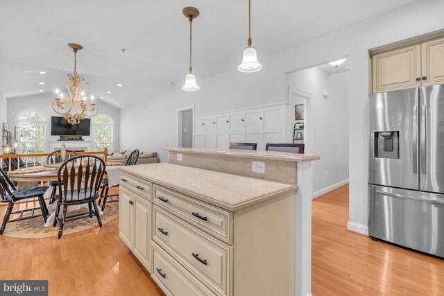 14745 Jennifer Ct, Issue, MD 20645 - kitchen featuring stainless steel fridge, cream cabinets, light wood-style flooring, a chandelier, and vaulted ceiling
