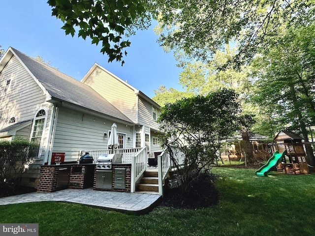 14745 Jennifer Ct, Issue, MD 20645 - back of house featuring a yard, a wooden deck, a playground, a patio area, and roof with shingles