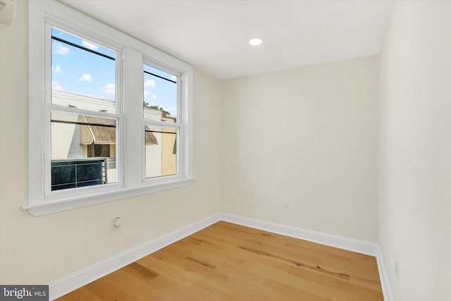 spare room featuring baseboards, light wood finished floors, and recessed lighting