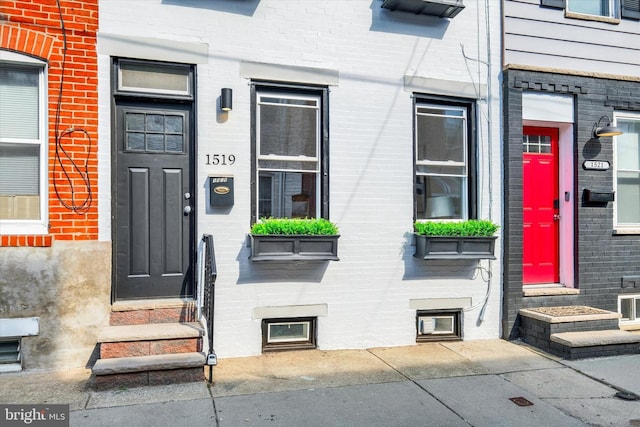 view of exterior entry featuring brick siding