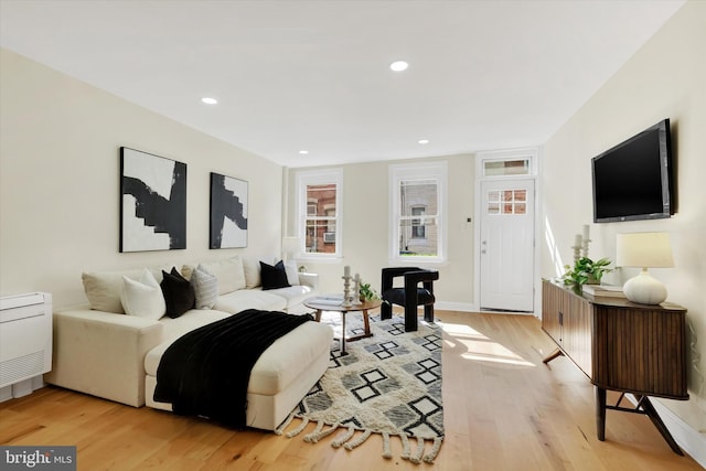 living area with light wood-style floors, baseboards, and recessed lighting