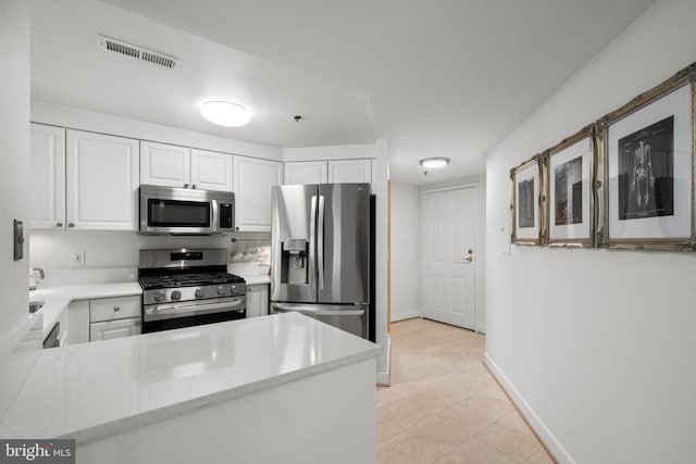 1045 N Utah St Unit 2-304, Arlington, VA 22201 - kitchen with stainless steel appliances, white cabinetry, baseboards, and a peninsula