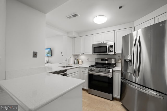 1045 N Utah St Unit 2-304, Arlington, VA 22201 - kitchen featuring stainless steel appliances, a peninsula, a sink, light countertops, and white cabinets