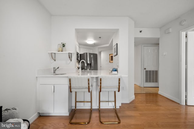 1045 N Utah St Unit 2-304, Arlington, VA 22201 - kitchen featuring stainless steel fridge, a sink, light countertops, and light wood finished floors