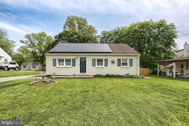 view of front of home featuring solar panels and a front yard