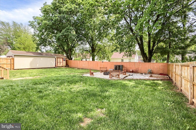 view of yard featuring a fire pit, a storage unit, and an outbuilding