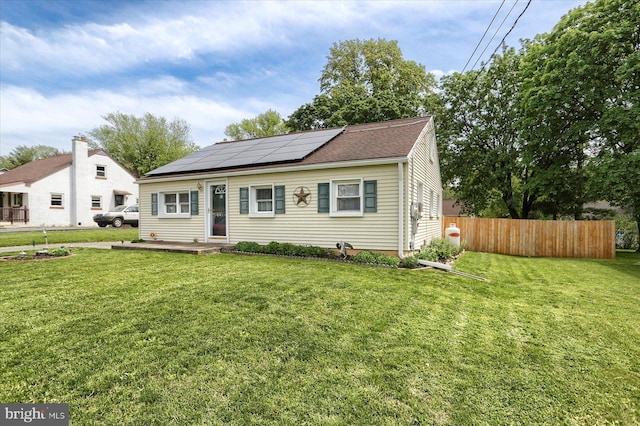 bungalow featuring solar panels and roof with shingles