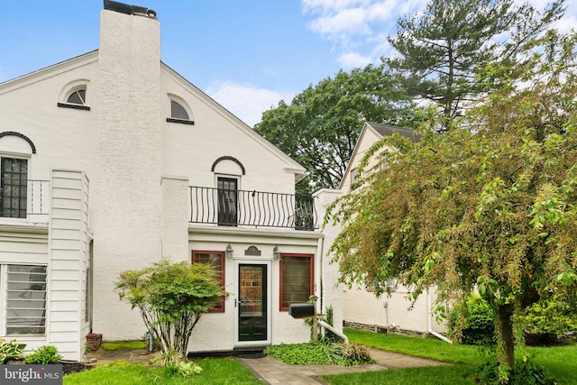 636 Old Lancaster Rd, Bryn Mawr, PA 19010 - view of front of home featuring a balcony, stucco siding, a chimney, and a front lawn