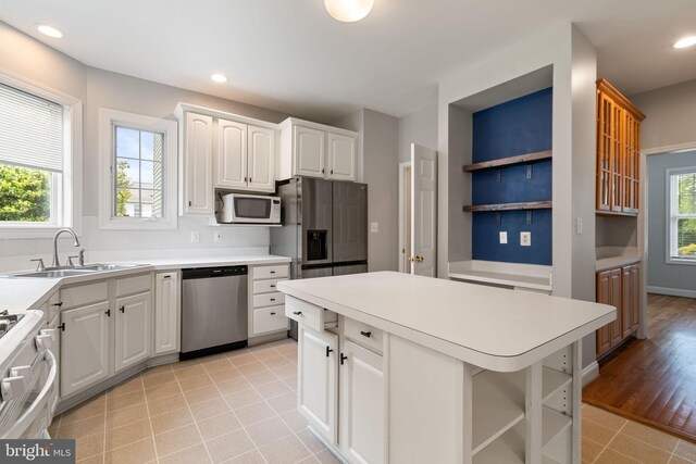600 Grace St, Herndon, VA 20170 - kitchen featuring stainless steel appliances, a sink, open shelves, decorative backsplash, and a center island