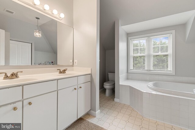 600 Grace St, Herndon, VA 20170 - full bath featuring double vanity, tiled bath, toilet, and lofted ceiling