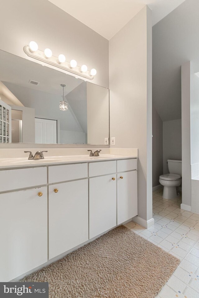 600 Grace St, Herndon, VA 20170 - full bathroom with double vanity, toilet, baseboards, and a chandelier