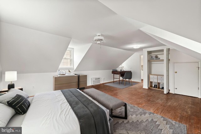 600 Grace St, Herndon, VA 20170 - bedroom featuring wood finished floors, vaulted ceiling, a wall unit AC, and baseboards