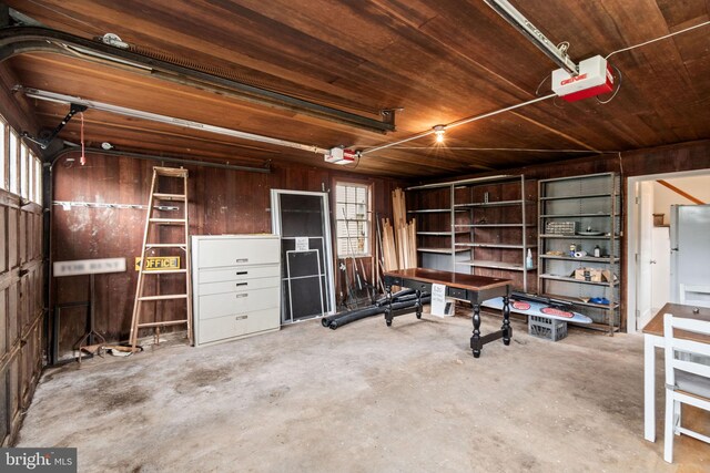 600 Grace St, Herndon, VA 20170 - garage featuring a garage door opener, wood walls, and wood ceiling