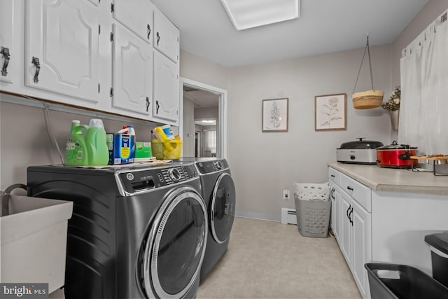 laundry area featuring washer and dryer, baseboard heating, cabinet space, light floors, and baseboards