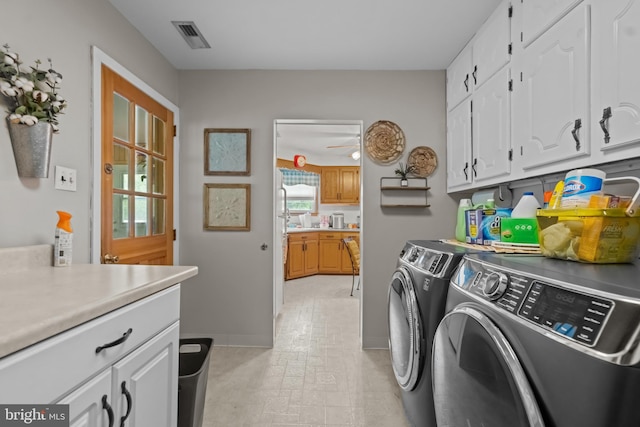 washroom with cabinet space, washer and clothes dryer, and baseboards