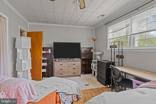 bedroom with wood finished floors, an office area, an ornate ceiling, and crown molding