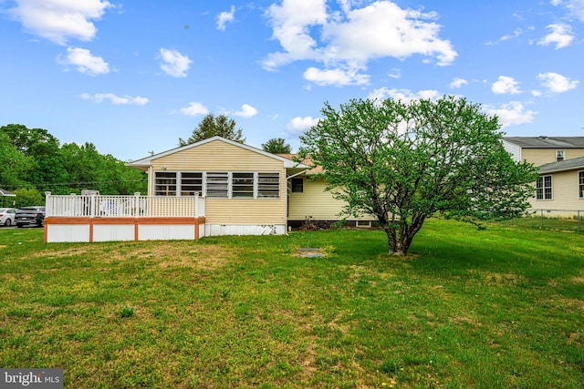 rear view of house featuring a lawn, a deck, and crawl space