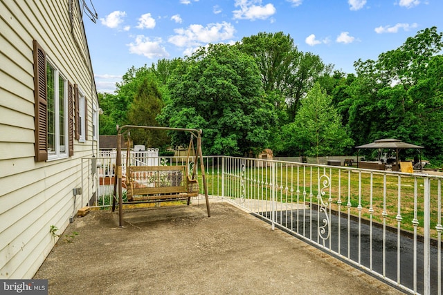 view of patio featuring a playground, view of wooded area, and a gazebo