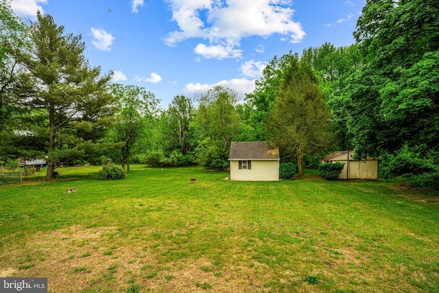 view of grassy yard with a storage shed and an outbuilding
