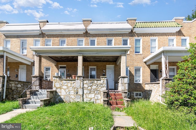 view of property with covered porch and brick siding