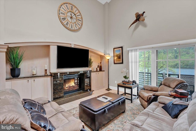 320 Hummingbird Way Unit 302, Lake Harmony, PA 18624 - living area featuring a towering ceiling, a premium fireplace, wood finished floors, and baseboards
