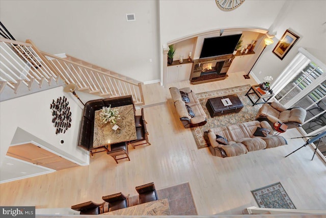 320 Hummingbird Way Unit 302, Lake Harmony, PA 18624 - living room with wood finished floors, a glass covered fireplace, arched walkways, stairs, and a high ceiling