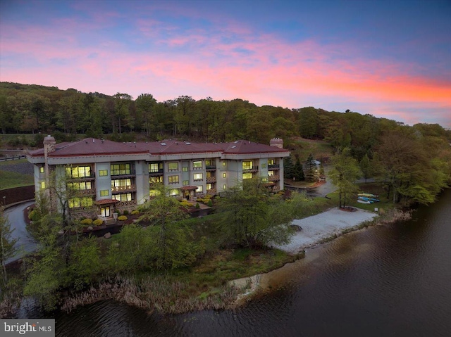 320 Hummingbird Way Unit 302, Lake Harmony, PA 18624 - back of house at dusk featuring a chimney, a water view, and a wooded view