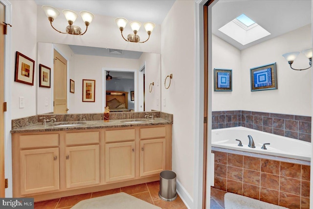 320 Hummingbird Way Unit 302, Lake Harmony, PA 18624 - ensuite bathroom featuring tile patterned floors, a skylight, double vanity, ceiling fan, and tiled tub