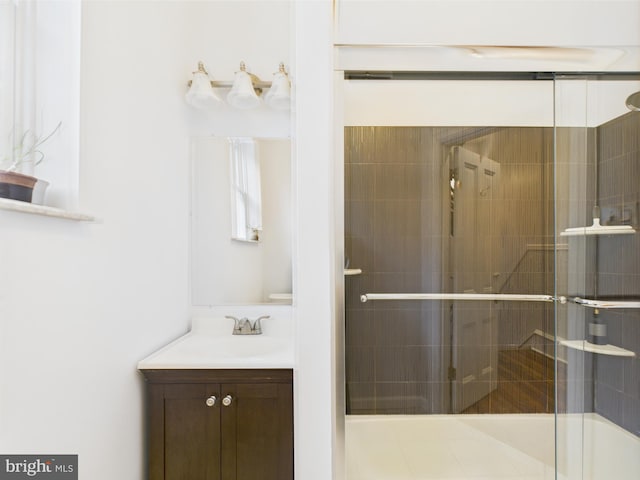 full bath with tiled shower and vanity