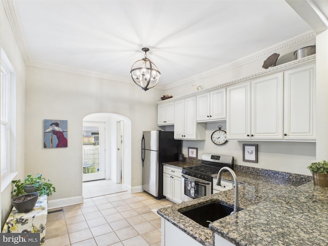 kitchen with stainless steel appliances, a sink, arched walkways, light tile patterned floors, and white cabinets