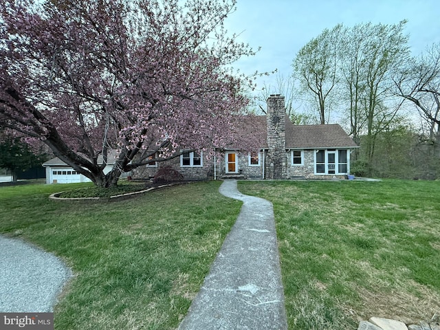 view of front facade featuring stone siding, a chimney, and a front yard