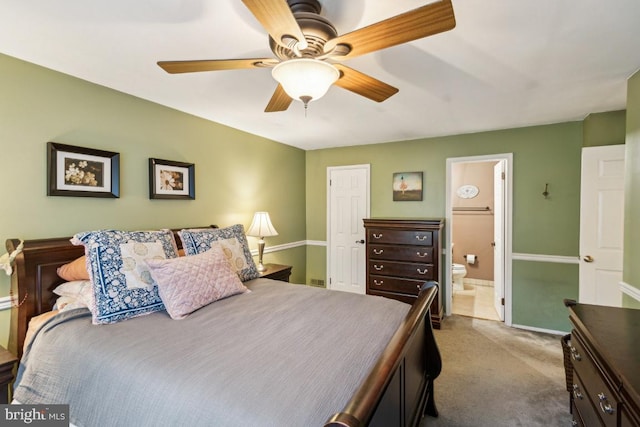 bedroom with carpet floors, ensuite bath, baseboards, and ceiling fan