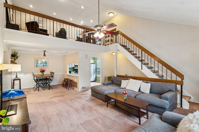 carpeted living room with a towering ceiling, stairway, ceiling fan, baseboards, and recessed lighting