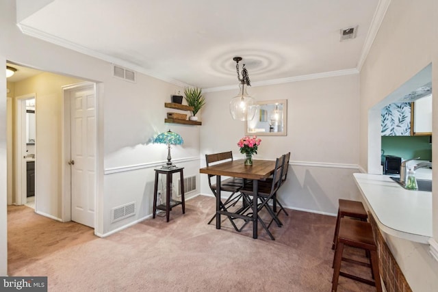 carpeted dining space with crown molding, a sink, and baseboards