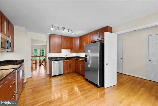 4516 4th Rd N, Arlington, VA 22203 - kitchen featuring appliances with stainless steel finishes, dark countertops, light wood-type flooring, a sink, and brown cabinetry