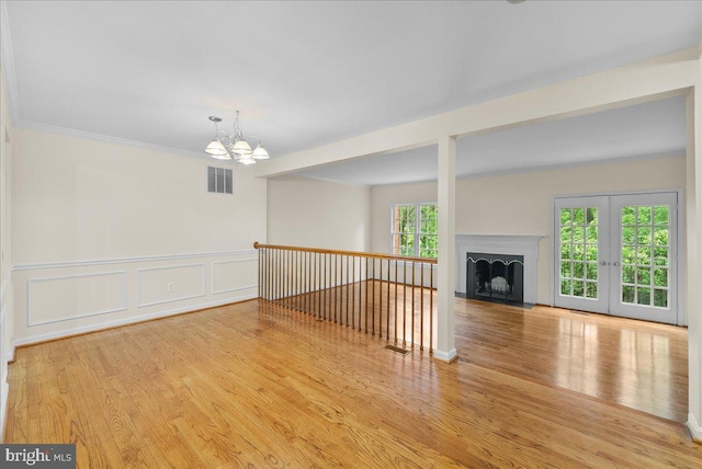 4516 4th Rd N, Arlington, VA 22203 - unfurnished living room featuring a chandelier, wood finished floors, wainscoting, a decorative wall, and a fireplace with flush hearth