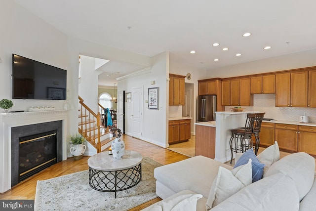 2714 Cabernet Ln, Annapolis, MD 21401 - living area with stairs, recessed lighting, light wood finished floors, and a glass covered fireplace