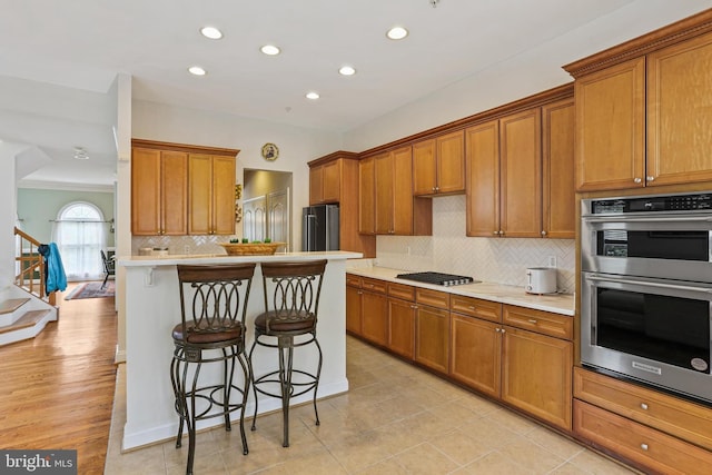 2714 Cabernet Ln, Annapolis, MD 21401 - kitchen featuring appliances with stainless steel finishes, a breakfast bar, brown cabinets, recessed lighting, and ornamental molding