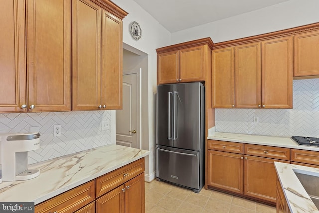 2714 Cabernet Ln, Annapolis, MD 21401 - kitchen featuring stainless steel appliances, decorative backsplash, brown cabinetry, and light stone counters