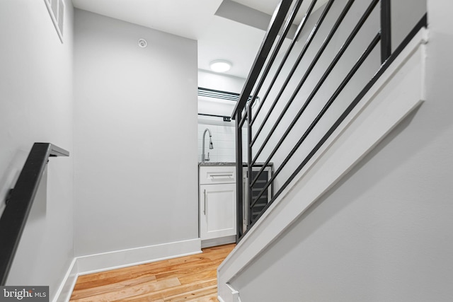 staircase with wood finished floors and baseboards